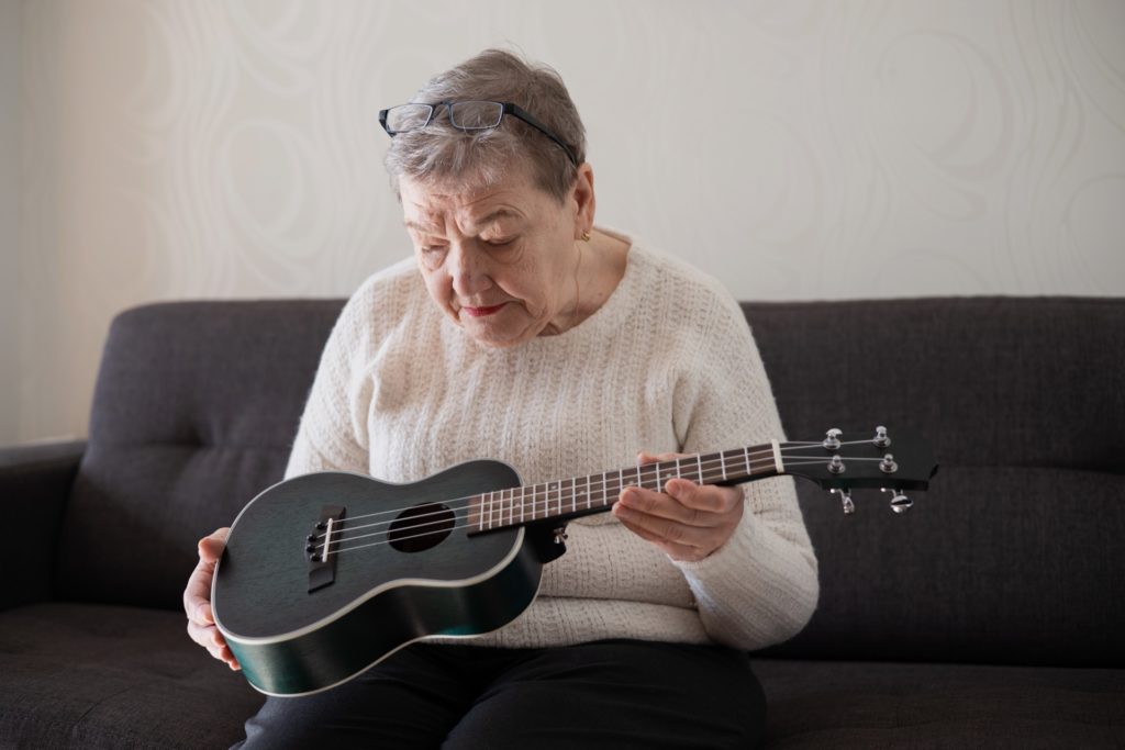 Frau beobachtet Ukulele