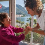 Infermiera a domicilio assiste un’anziana a Lugano con vista sul lago
