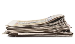 Pila di giornali che rappresenta un articolo di opinione sulle cure a domicilio e sulla partecipazione ai costi in Ticino.