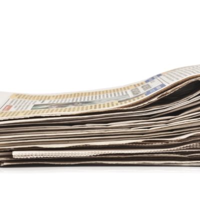 Pila di giornali che rappresenta un articolo di opinione sulle cure a domicilio e sulla partecipazione ai costi in Ticino.